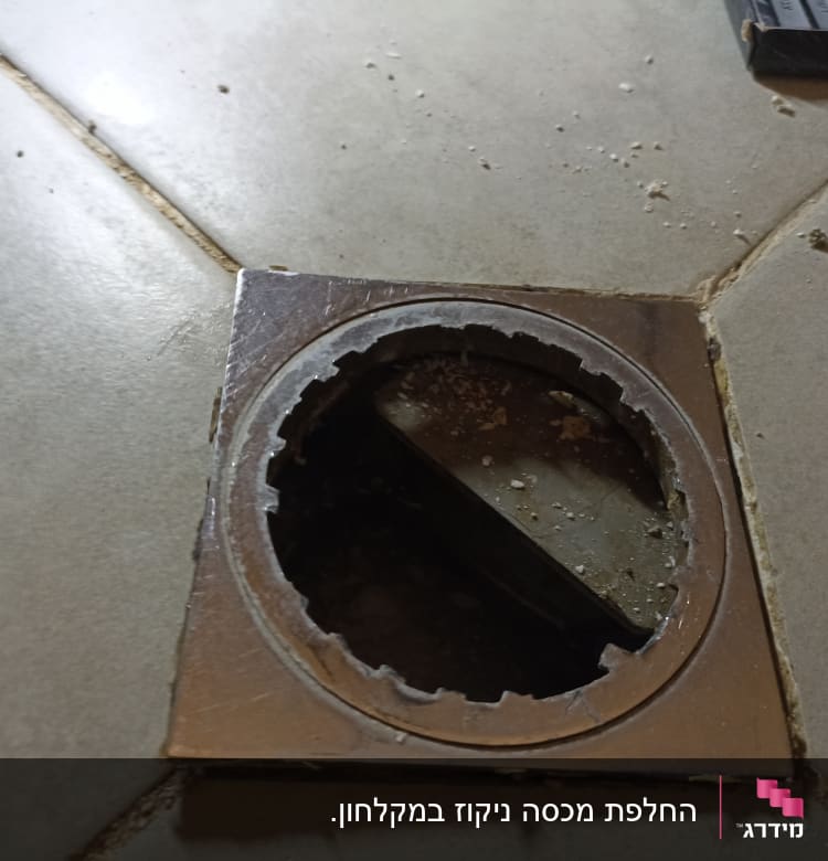 פתח ניקוז ברצפה עם לכלוך מסביב